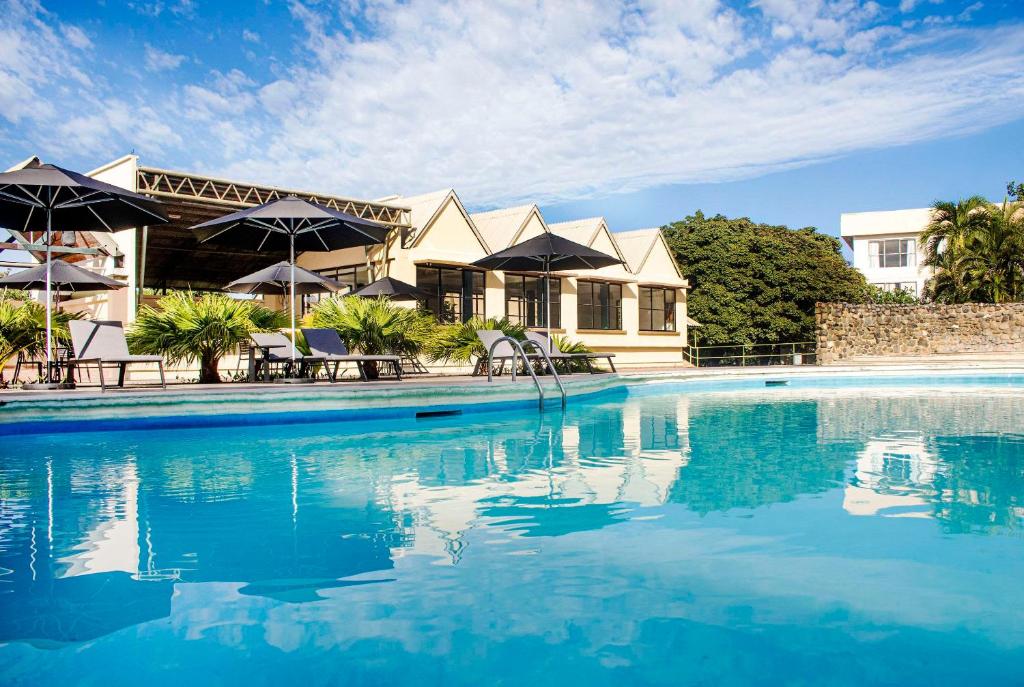 奇特雷Hotel Faranda Guayacanes, a member of Radisson Individuals的一座带游泳池的度假村,位于一座建筑前