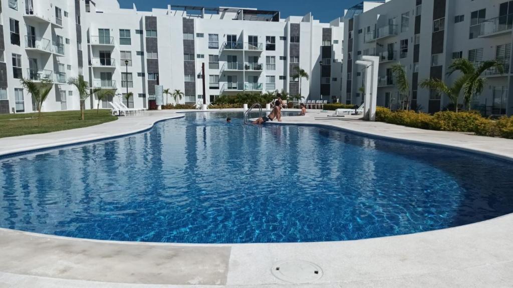 阿卡普尔科Departamento en Acapulco Diamante的部分公寓大楼前的游泳池