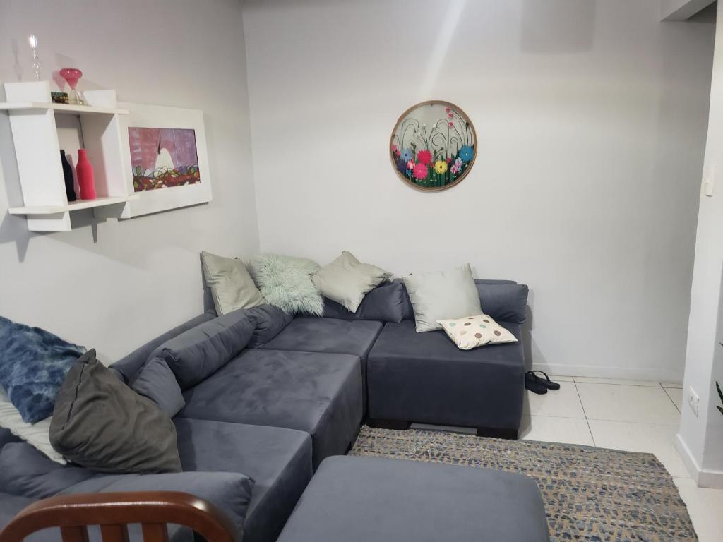 大坎普Casa verde的客厅配有沙发和墙上的盘子