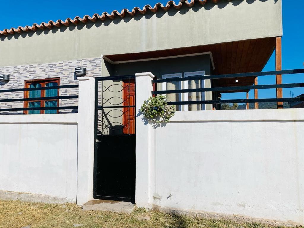 ChicoanaSueño de Chicoana的一间白色的房子,设有黑色的门和栅栏