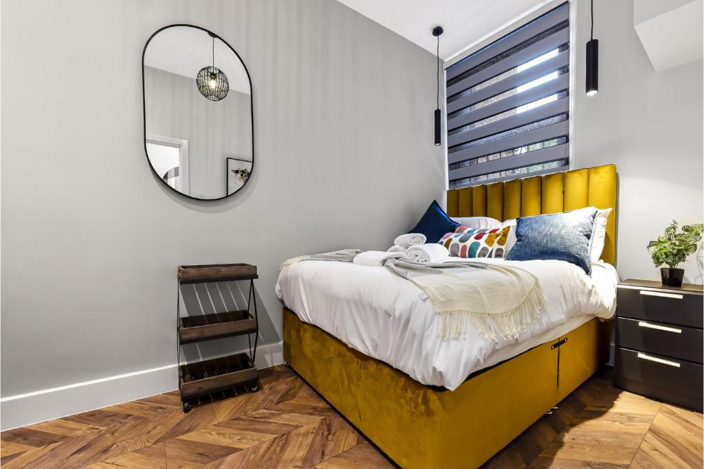 伦敦Lovely 2 BR with Grill的一间卧室配有黄色的床和镜子