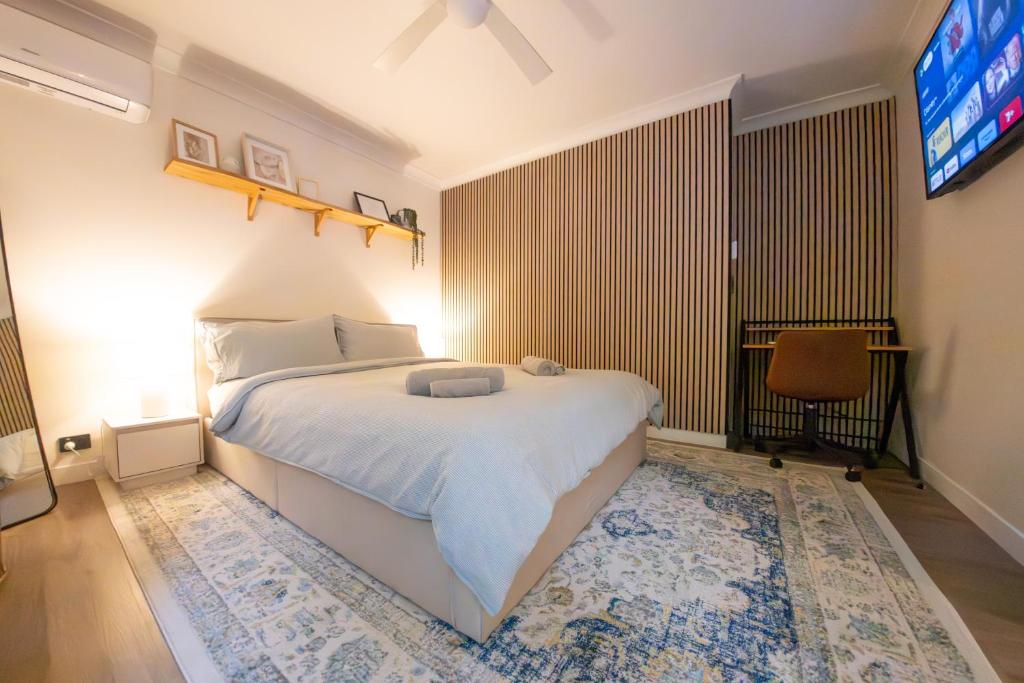Tanah MerahAlina's Peaceful Studio的卧室配有白色的床和电视