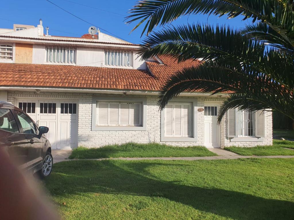 马德普拉塔Casa a 100 metros del mar, garaje doble的前面有棕榈树的房子