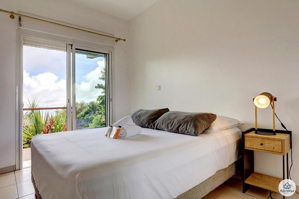 圣丹尼斯Ti Kaz Bellevue - villa avec vue mer - jacuzzi - Saint-Denis的一间卧室设有一张大床和大窗户