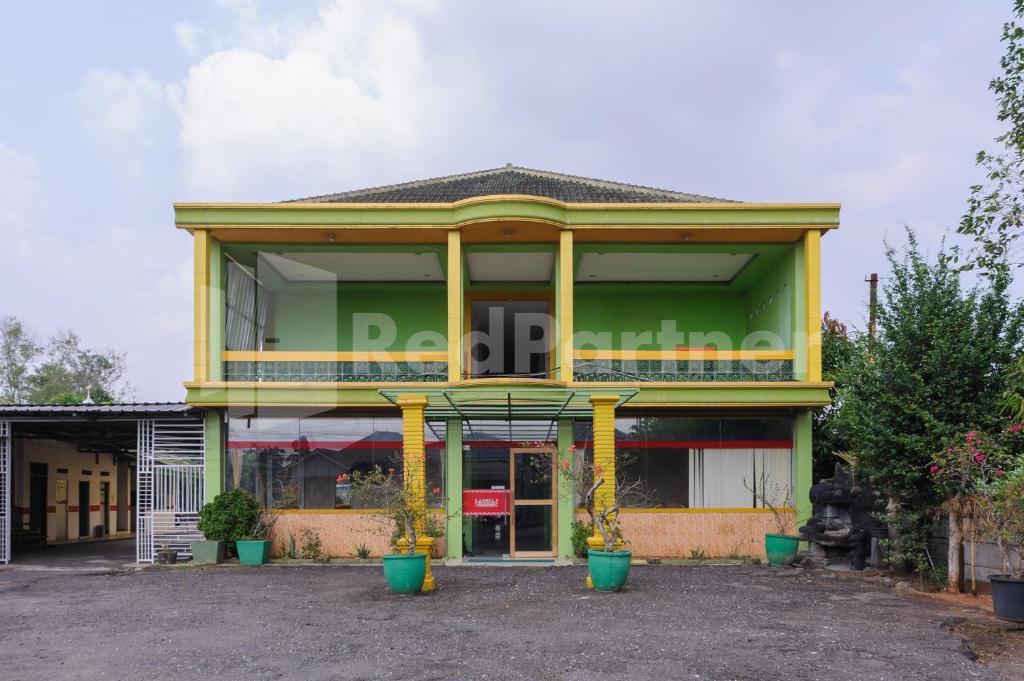 NegarasakaHomestay Hj Suharti Natar Lampung RedPartner的前面有黄色柱子的建筑