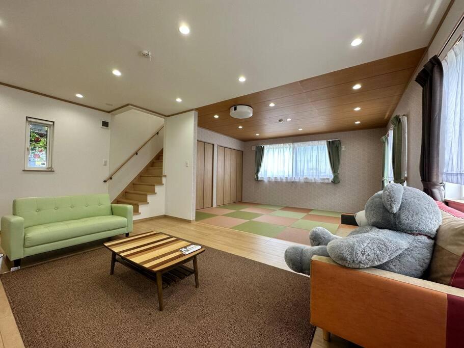 白滨Shirahama Yamate Rent Villa A-2-3的客厅,沙发上摆放着大泰迪熊