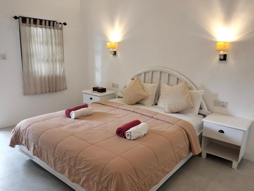 吉利特拉旺安White Coconut Resort的一间卧室配有一张大床和两个枕头