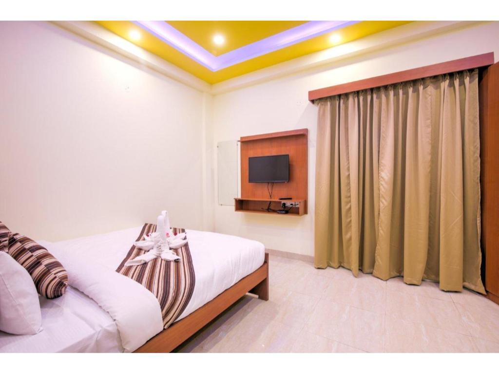 大诺伊达Kusum House的一间卧室配有一张床和一台电视。