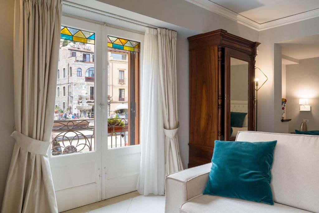 陶尔米纳Al Duomo Rooms & Flats的带沙发和窗户的客厅