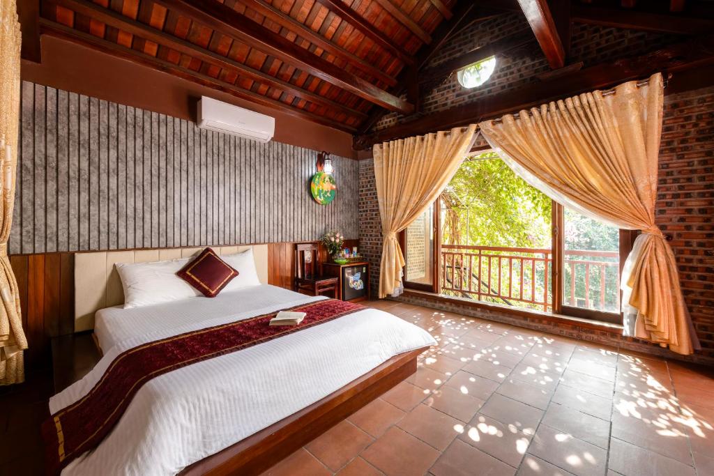 宁平Tam Coc Ngoc Linh Bungalow Ninh Bình的一间卧室设有一张床和一个大窗户