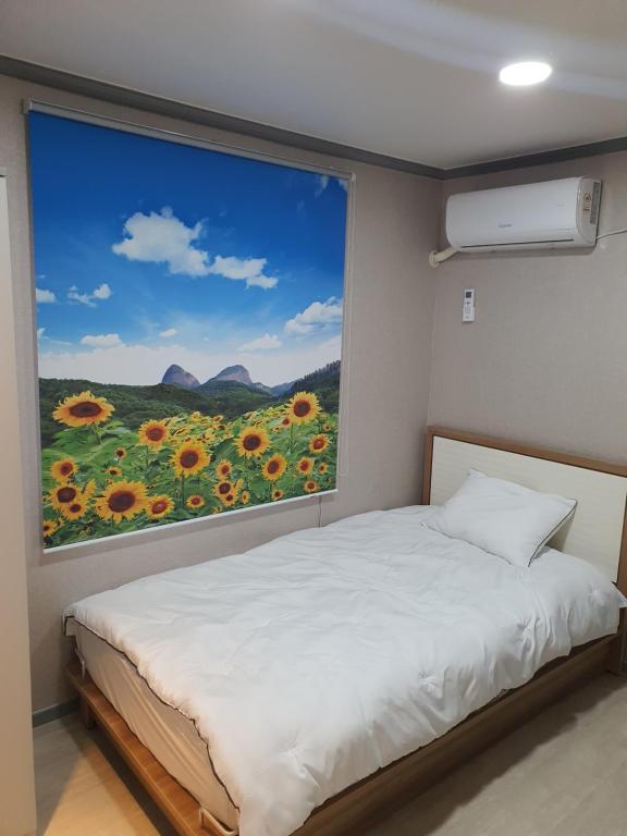 釜山Ara Guesthouse的一间卧室设有窗户,享有向日葵的景色