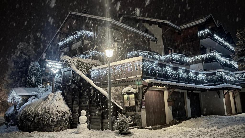 普拉洛尼昂拉瓦努瓦斯Chalet Hôtel Les Airelles的一座建筑物前的雪覆盖的房子