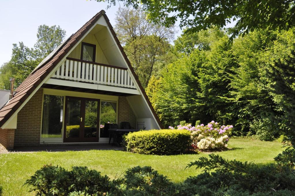 ZwiggelteSummio Bungalowpark Het Hart van Drenthe的一座带花园和鲜花的小房子