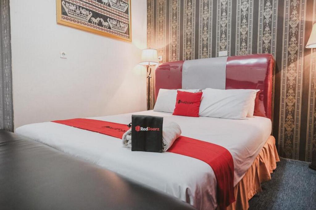 班达楠榜RedDoorz Plus @ Jalan Raden Intan Lampung的酒店客房带两张带红白色枕头的床