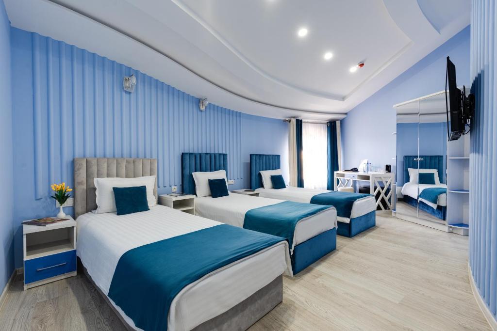 塔什干Shoxjahon Hotel - 600 Mbps Internet的酒店客房配有两张床和一张书桌