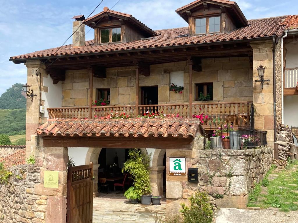 CiceraLa Valuisilla, hotel rural的一座古老的石头房子,设有阳台和大门