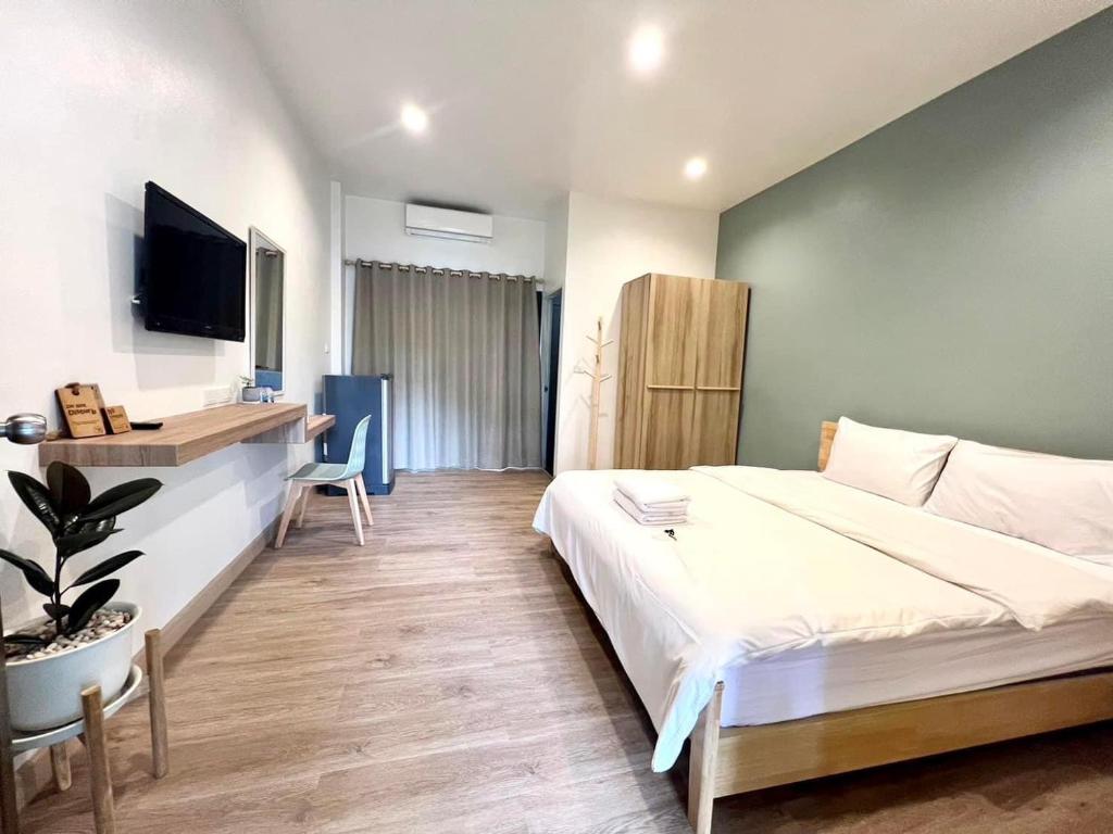 坤敬945酒店的卧室配有一张白色大床和一张书桌