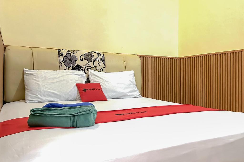 巴厘巴板RedDoorz near Wisma Cahaya Abadi Sepinggan Aiport的床上摆着两袋子的床