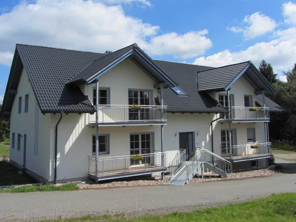NeuenbauAm Alten Forsthaus的黑色屋顶的白色房子