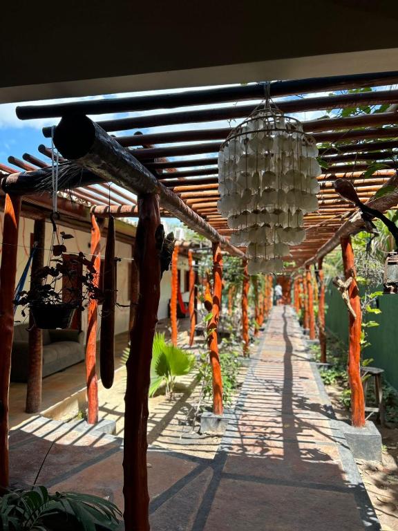 日若卡-迪热里科阿科阿拉Imperio dos Bambus Suites的一条带遮盖的走廊,拥有橙色和白色的装饰