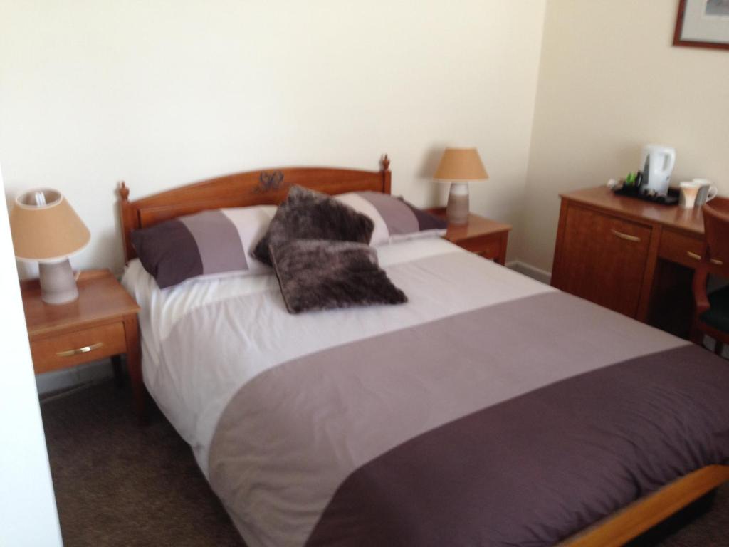 霍利韦尔维多利亚酒店的一间卧室配有一张大床和枕头