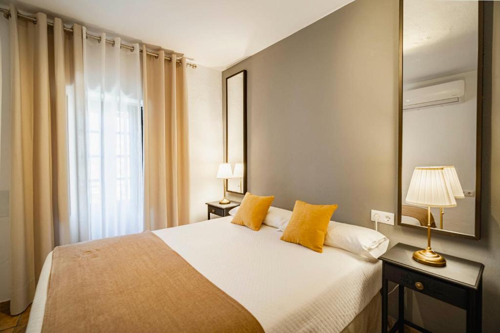 贝赫尔-德拉弗龙特拉拉苏尔塔纳维吉尔酒店的一间卧室配有一张带黄色枕头的大床