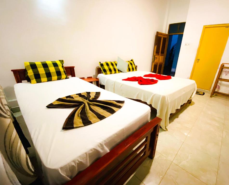 蒂瑟默哈拉默Happy Resort Yala的配有两张床的客房内。
