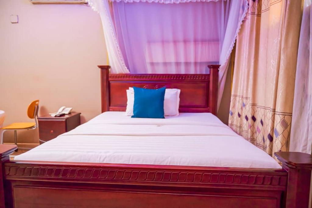 坎帕拉Twin towers hotel的一间卧室配有一张带蓝色枕头的床