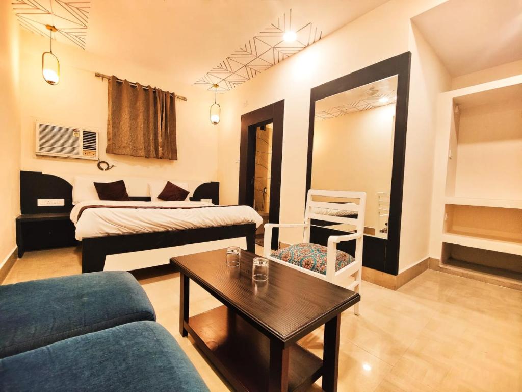 SatnaHotel Mahamaya的带沙发、床和桌子的客厅