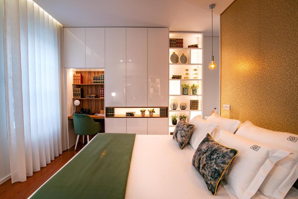 吉马良斯GuimaGold的卧室配有一张白色大床和一张书桌
