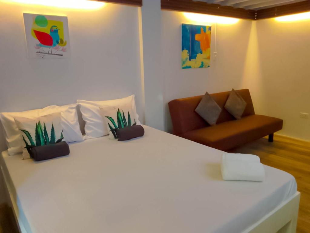 八打雁Coco Cavana Resort的卧室配有白色的床和椅子