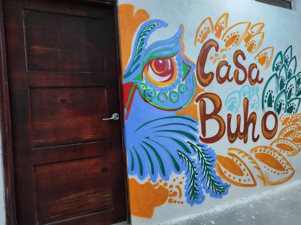帕纳哈切尔Casa Búho的墙上有画牌的门