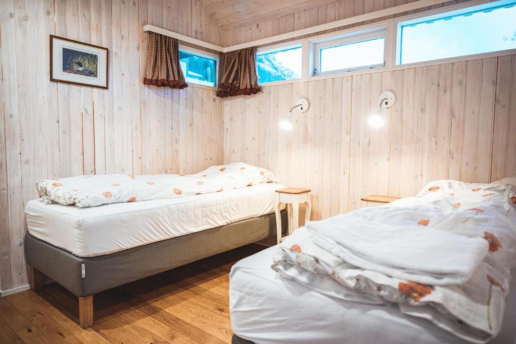 霍芬Old Cottages的配有木墙和窗户的客房内的两张床