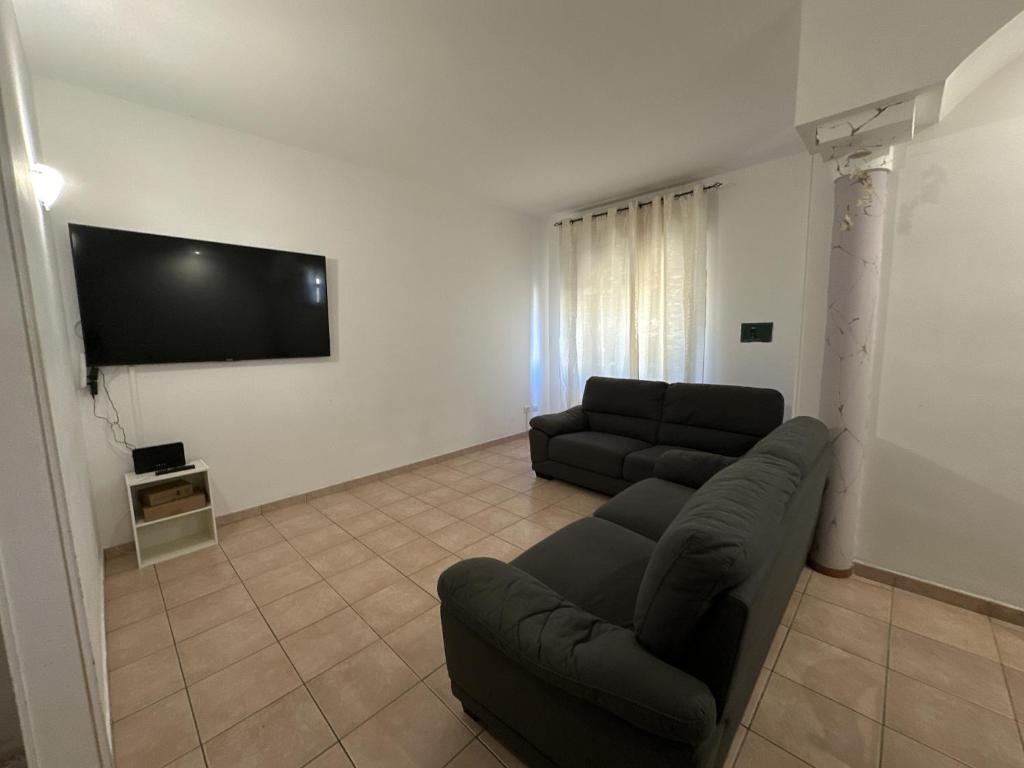奥尔比亚Olbia via modena的带沙发和平面电视的客厅