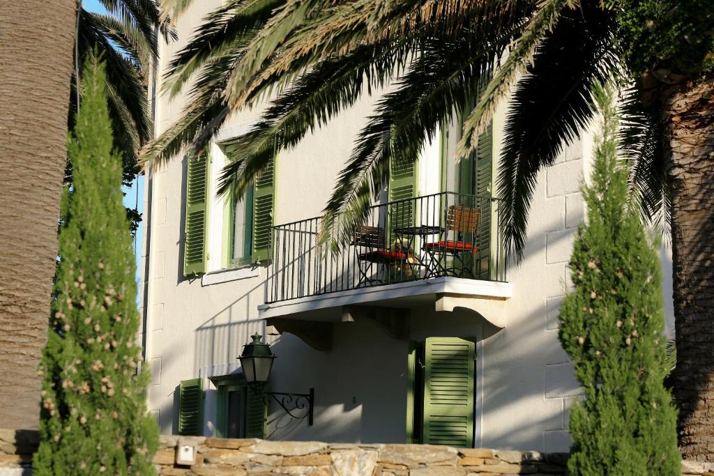 厄尔巴隆加Demeure Castel Brando Hôtel & Spa的带阳台和棕榈树的白色建筑