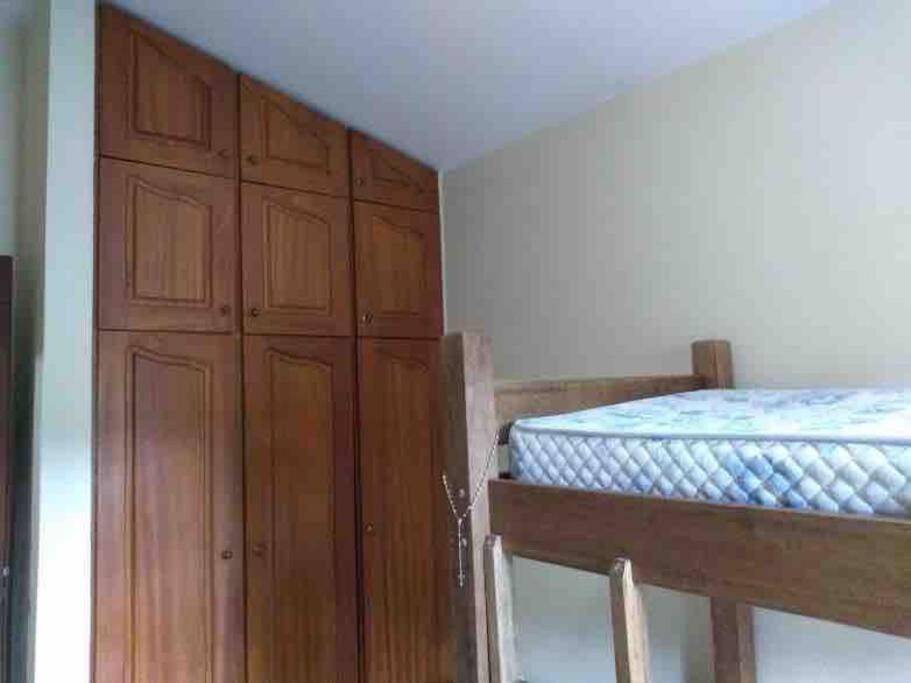 圣罗克Casa em São Roque Roteiro do Vinho的一间卧室配有一张床和木制橱柜