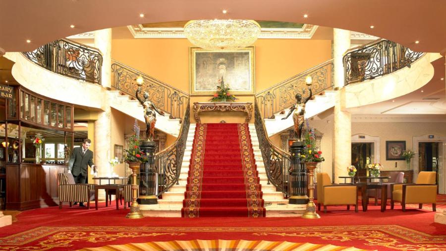 塔拉莫尔布里奇休闲Spa俱乐部酒店的一座铺有红地毯的建筑中的楼梯