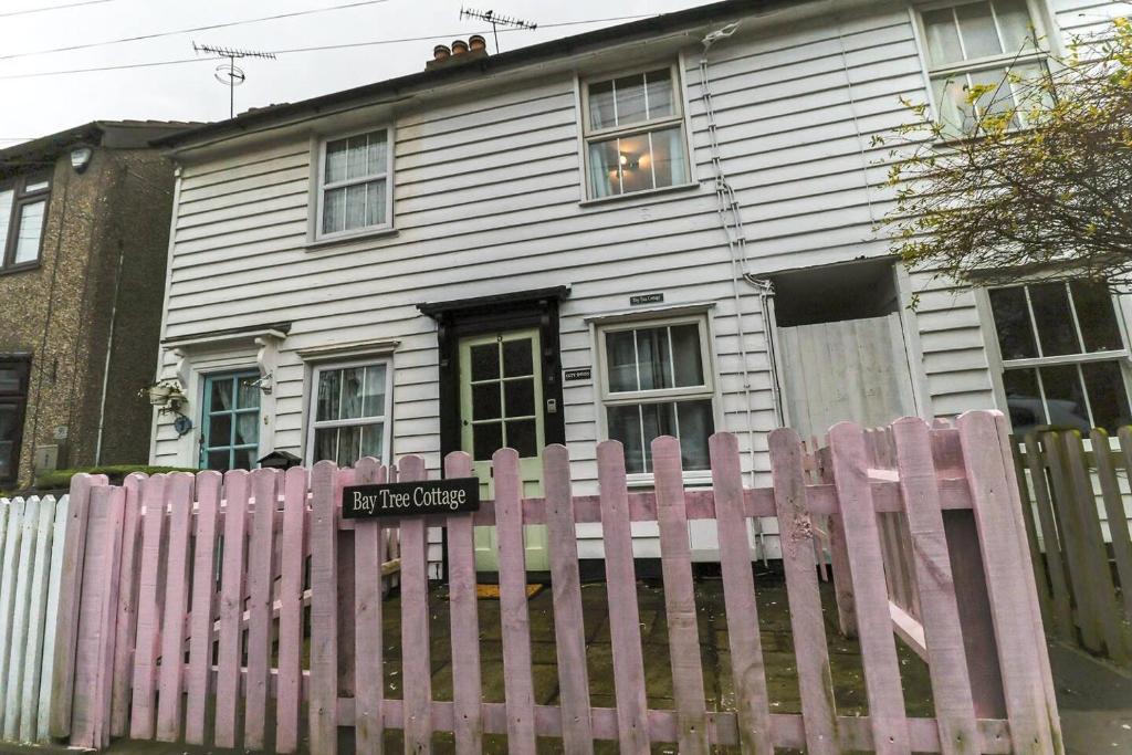 克劳奇河畔伯纳姆Beautiful 3-Bed Cottage in Burnham-on-Crouch的白色房子前面的粉红色围栏