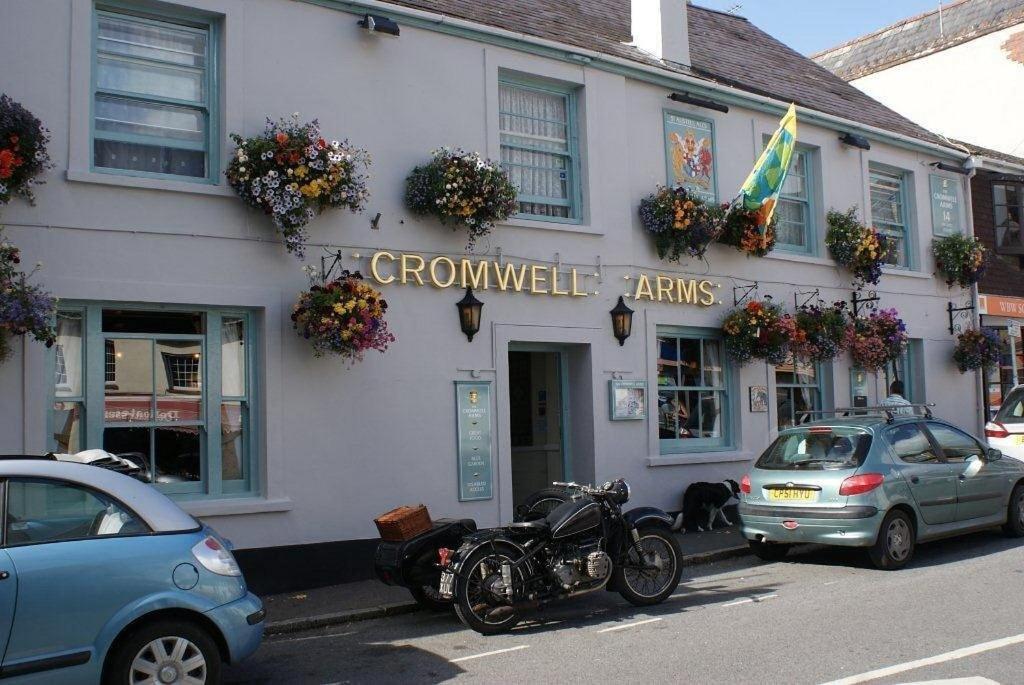 巴维特雷西The Cromwell Arms Inn的停在大楼前的摩托车