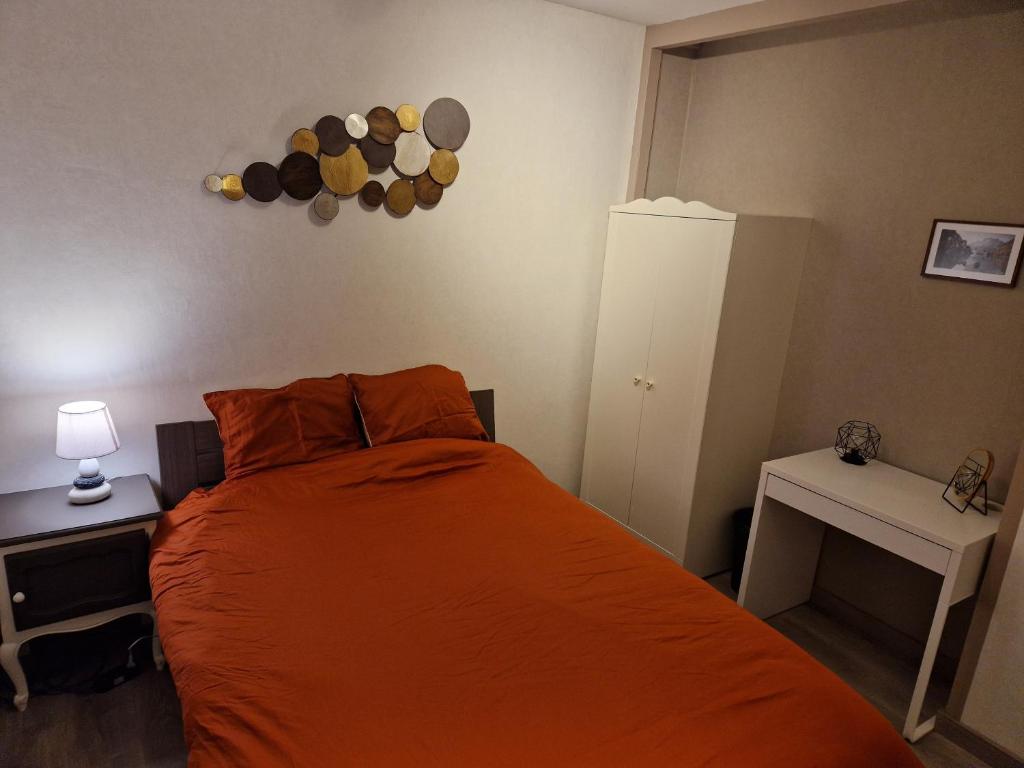 RamilliesChambre au calme à Ramillies - chez Ben的一间卧室配有一张带橙色床罩的床