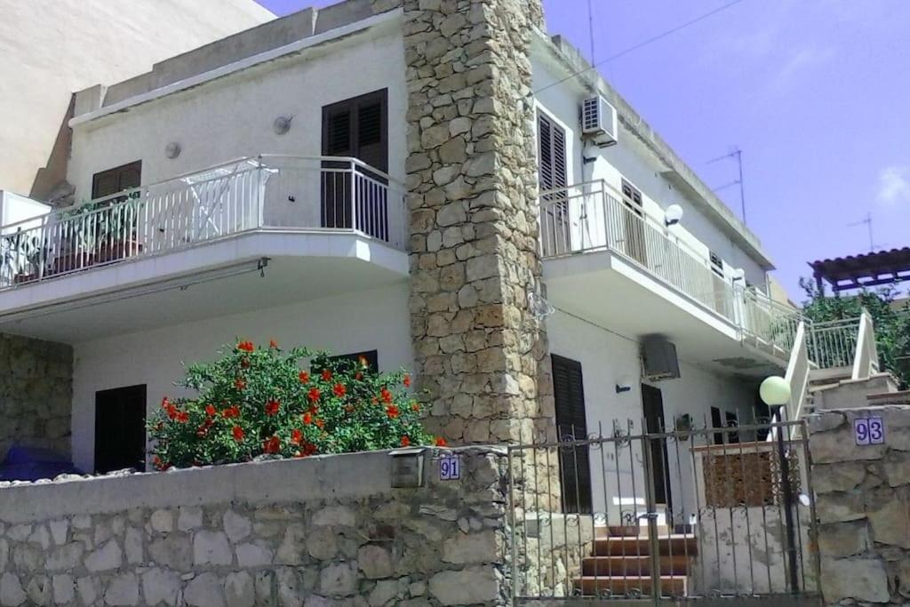 兰佩杜萨Splendido appartamento a Lampedusa, con terrazzo !的带阳台和石墙的白色房屋