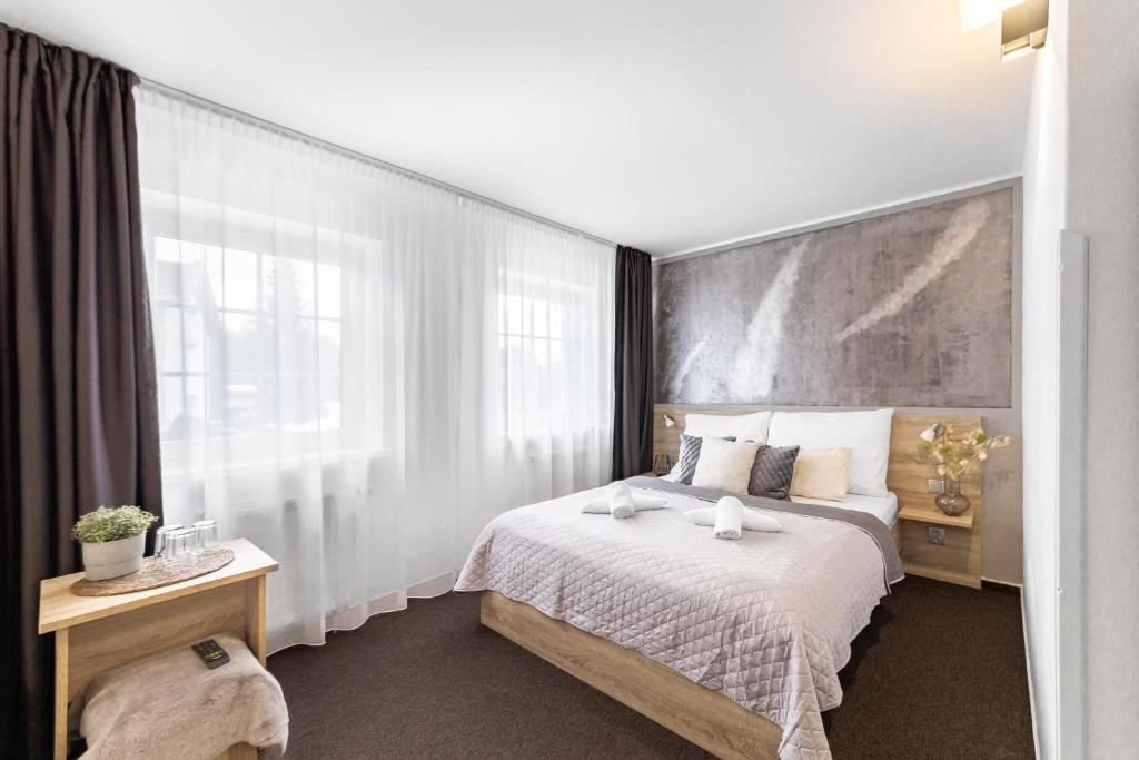 Filipovice佩坡维卡旅馆的一间卧室设有一张床和一个大窗户