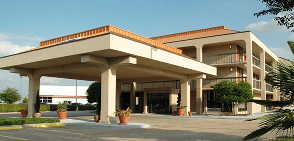 达拉斯Executive Inn的停车场内有门廊的大建筑