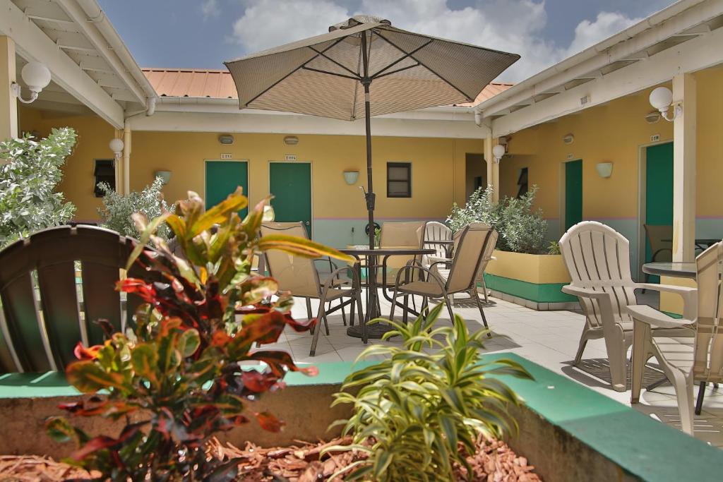 辛普森湾卡尔别致酒店及会议设施的庭院配有桌椅和遮阳伞。