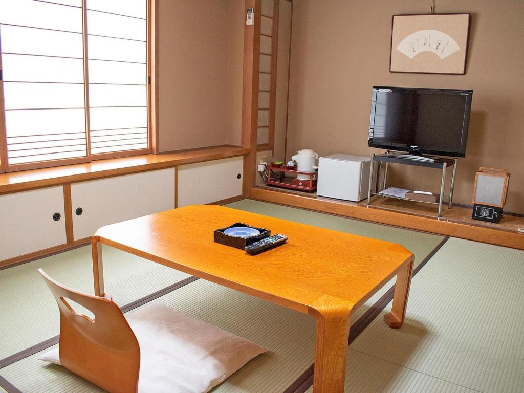 EchizenHotel Akaboshitei - Vacation STAY 57417v的客厅配有木桌和电视。