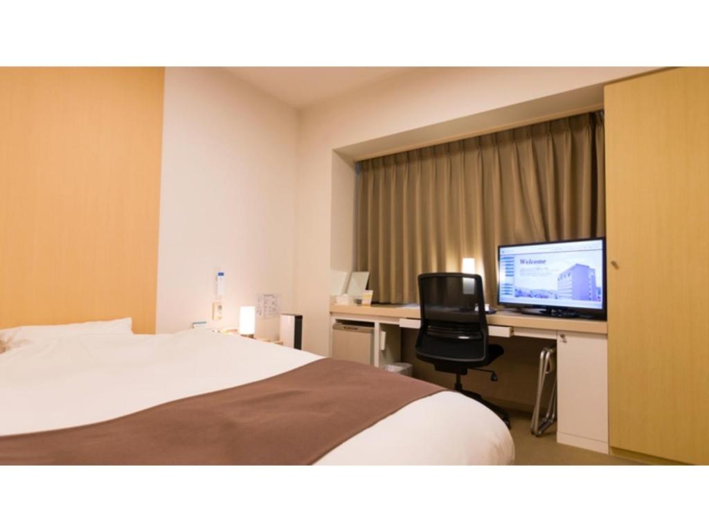 高山Spa Hotel Alpina Hida Takayama - Vacation STAY 51628v的酒店客房配有一张床和一张带电脑的书桌
