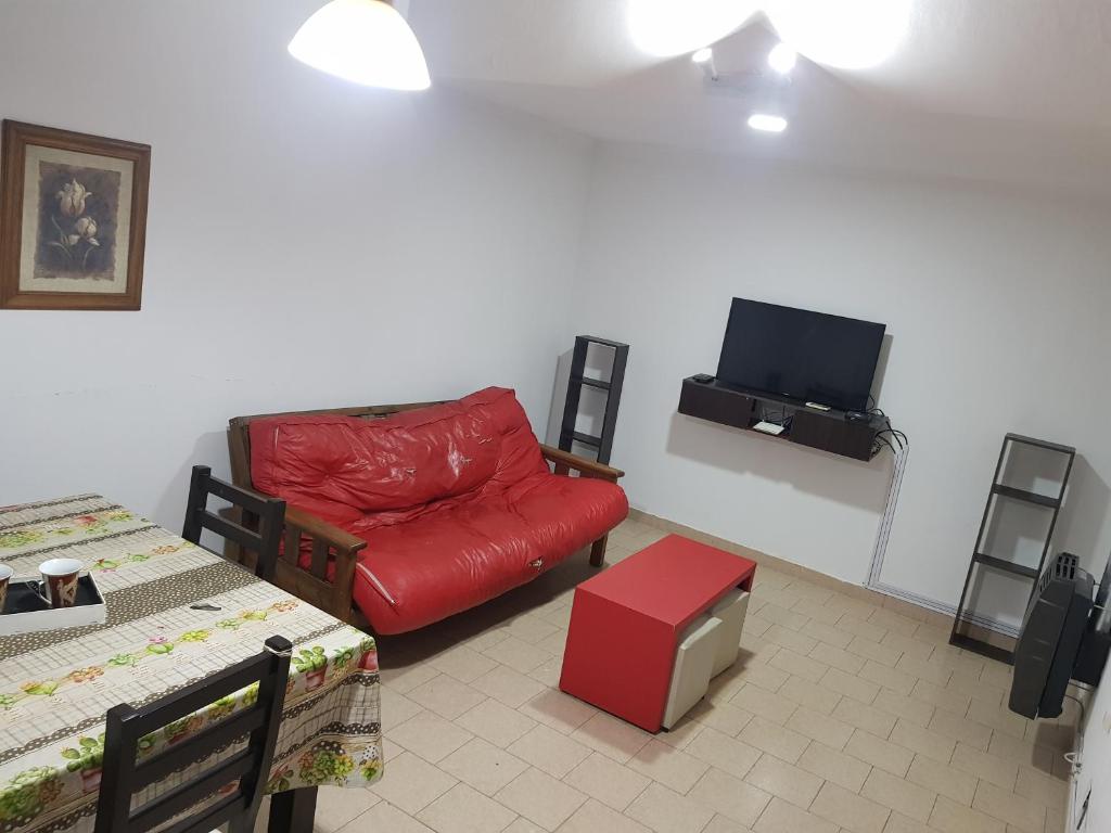 圣罗莎La esquina - Alquiler temporario的客厅配有红色沙发和平面电视