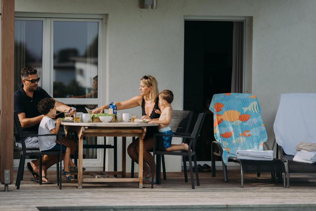 路茨曼贝格Ferienhaus XL的坐在餐桌旁与家人一起吃饭的女人