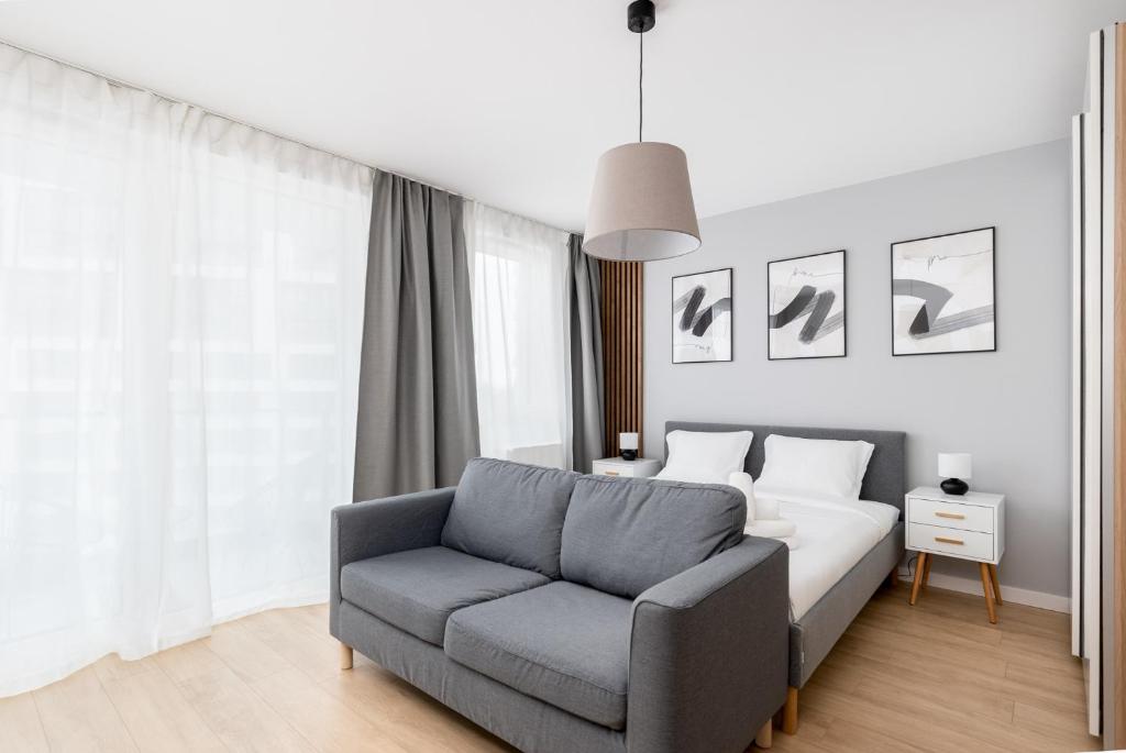 克拉科夫Tauron Modern Studio的一间卧室配有一张床、一张沙发和一把椅子