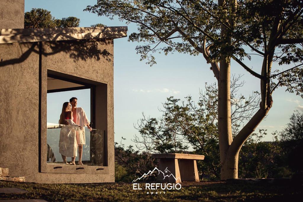 维拉塞拉尼塔El Refugio Apart的新娘和新郎站在窗户旁